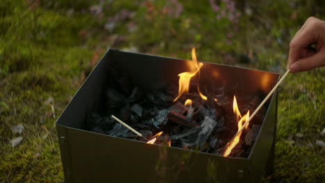 Flamme-Im-Holzkohlegrill-Person-Mischt-Kohlen-Detailansicht-Zeitlupenaufnahme-Camping-Und-Picknick-In-Der-Natur